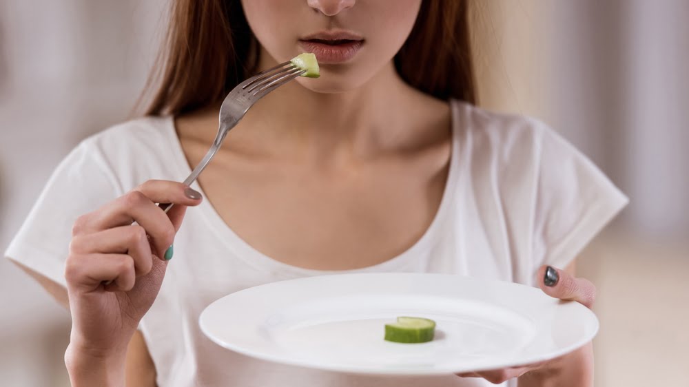 mulher com receio de comer muito