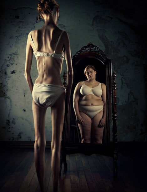 mulher anorética que se olha no espelho e se vê gorda