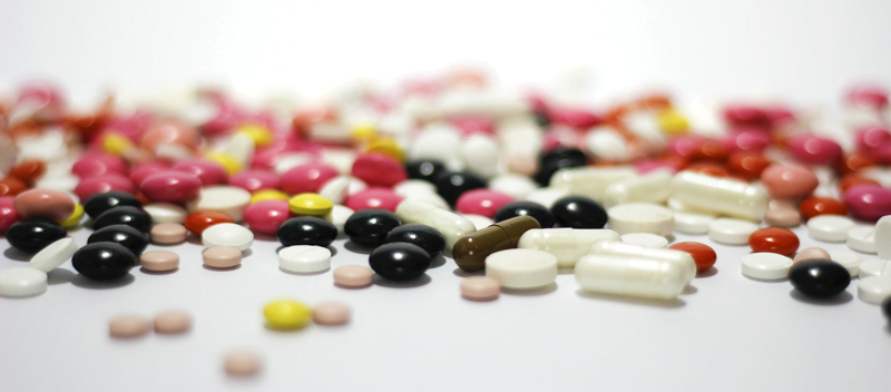 comprimidos espalhados ilustrando o excesso de medicação e a abordagem farmacológica