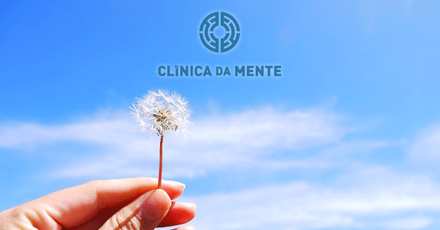 pessoa a segurar um dente-de-leao com o ceu azul como fundo