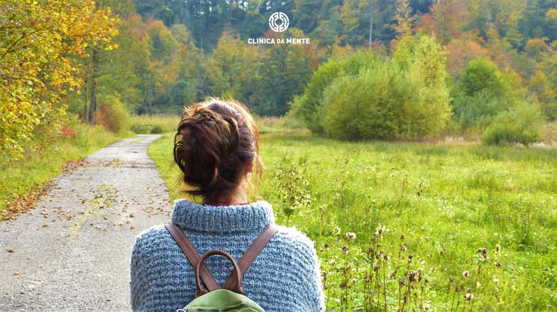 mulher prepara-se para uma nova etapa perante um caminho a percorrer no meio do campo