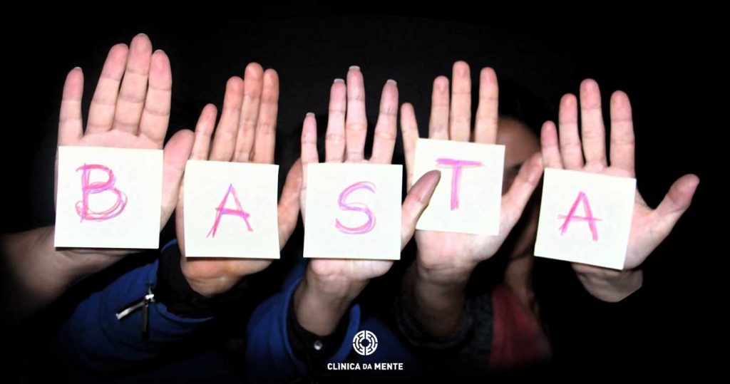 cinco mãos com a inscrição BASTA
